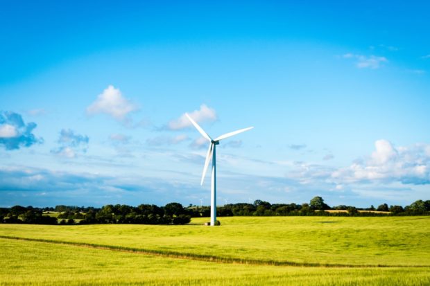 Wind turbine on a landscape of grass and trees