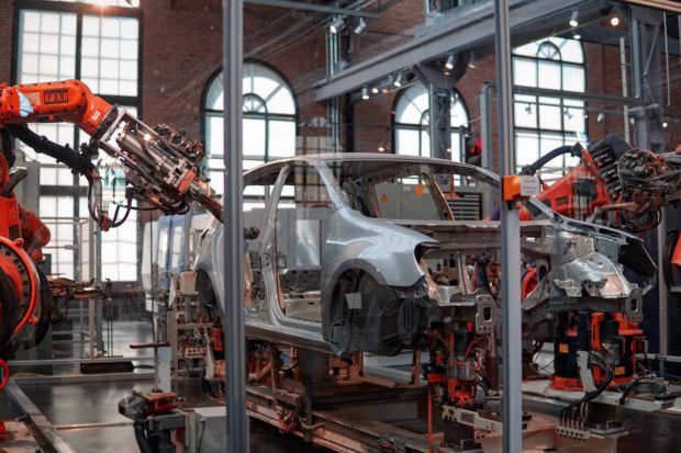 Photo of a car being assembled by robots in a factory