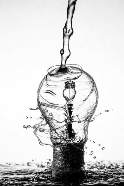 Black and white image of a lightbulb being splashed with water, representing the innovation that climate finance can fund.